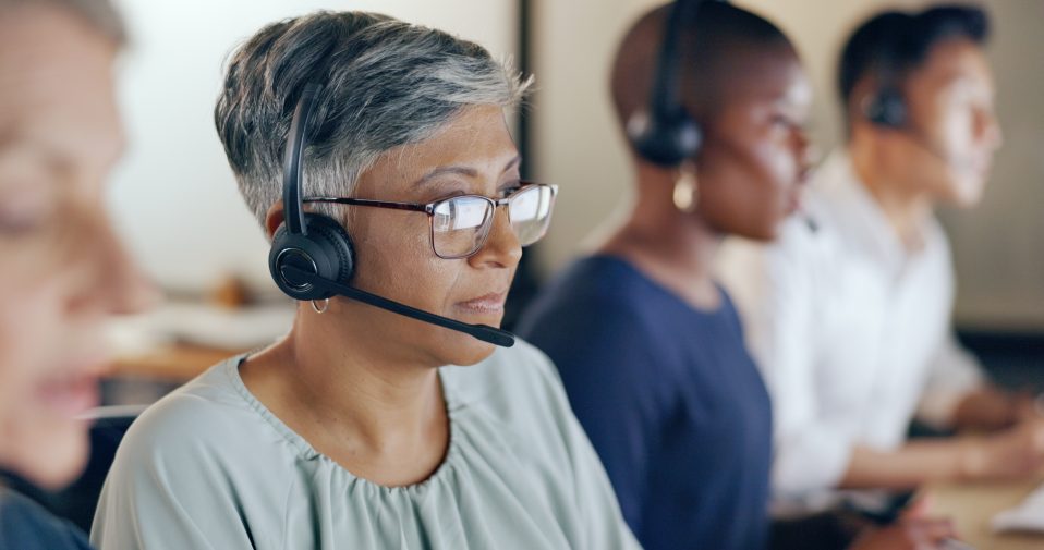 Lady with glasses sat at desk on computer